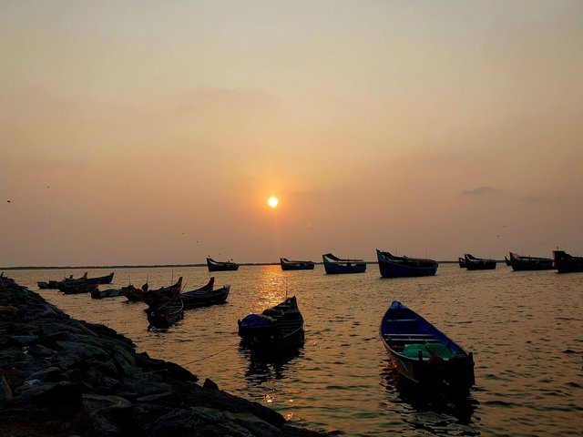 Fishing boats moored in a harbour at sunset